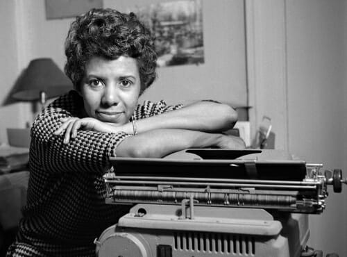 Photo: Lorraine Hansberry leaning on a typewriter in her apartment