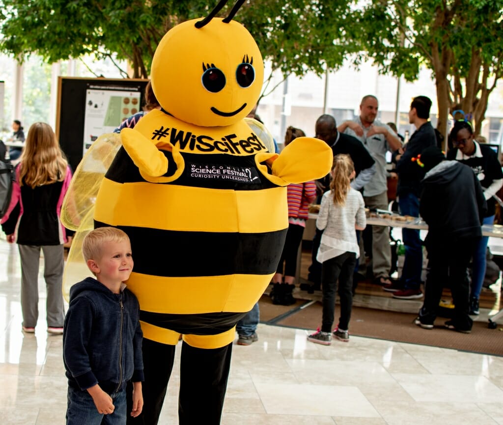 Beesly, the Wisconsin Science Festival mascot, poses for a photo with a fan. She's a honeybee, the Wisconsin state insect.