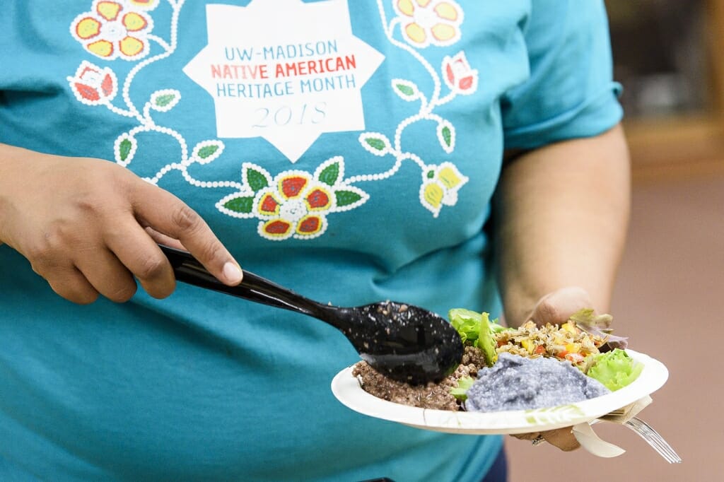 A close-up of a woman filling her plate with food.