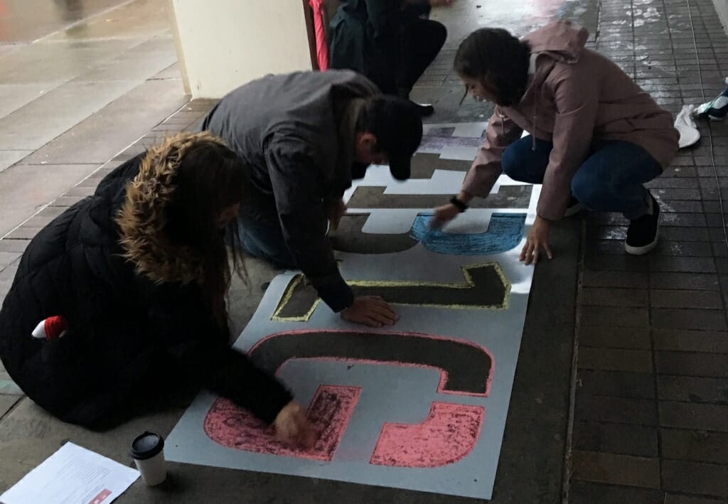 Students working for the Big Ten Voting Challenge chalk the ground outside the Memorial Library polling place early on Election Day morning, Nov. 6.