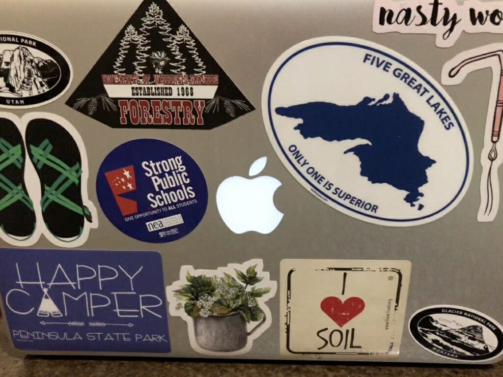 Junior Emma Froelich's laptop, which features several camping and outdoors-ey stickers, as well as "Nasty Women" and "Strong Public Schools" stickers