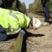 Photo: Worker in hardhat crouching and looking down track