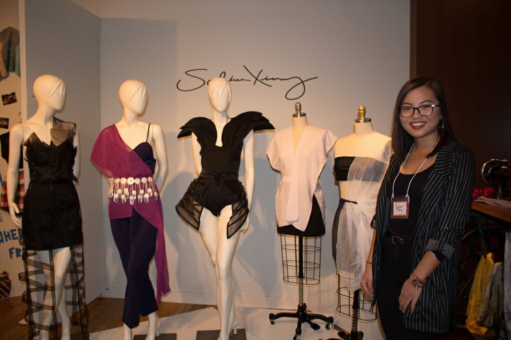 Photo: A woman with several mannequins sporting clothing she designed.
