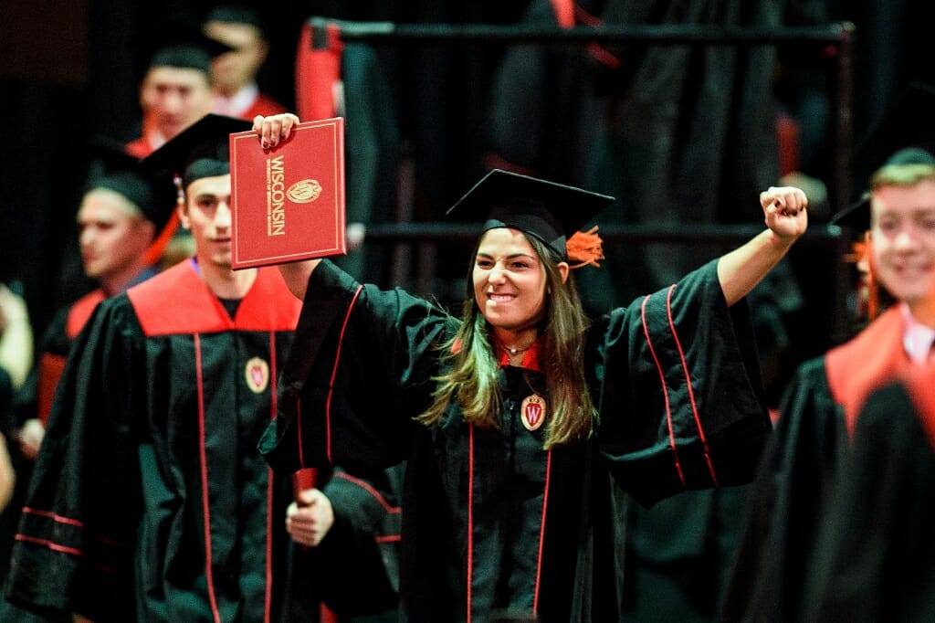 Photo of a graduate doing a celebratory fist pump after walking the stage.