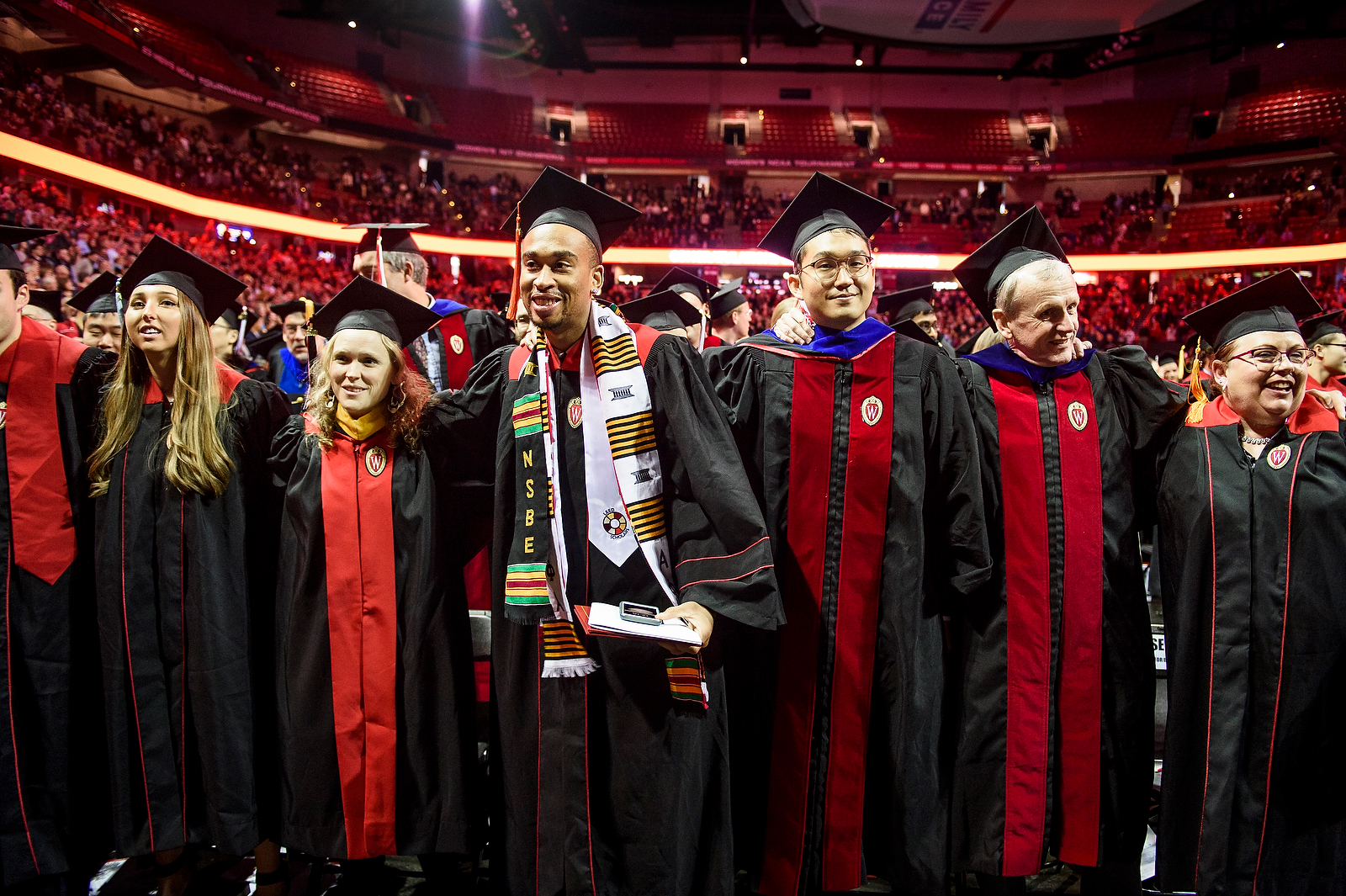 Photo of graduates arm in arm singing "Varsity."