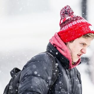 Photo: Student grimacing as he walks in the snow