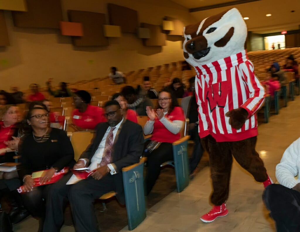 Photo: Bucky Badger charges into a filled auditorium.