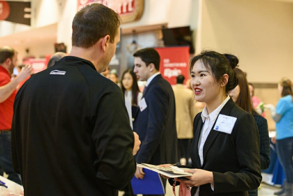 UW undergraduate Yueyi Tang (right) talks with a recruiter from American Family Insurance.