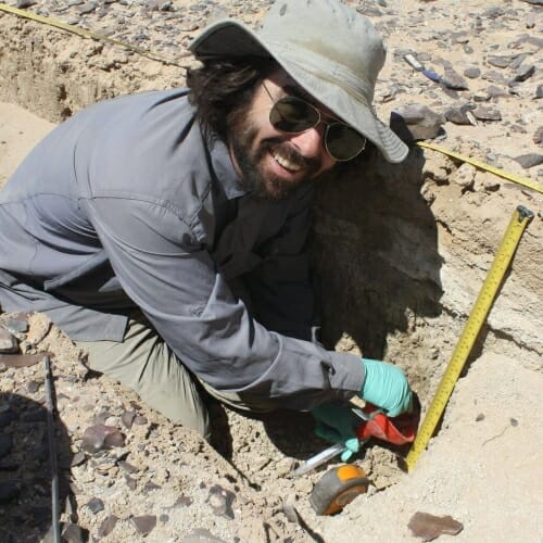 Photo: A man digging on an archaeological site.