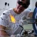 Photo: Drier in dark goggles working with flame on glass instrument