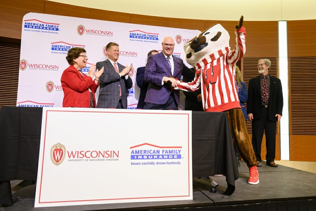 Photo: Bucky Badger shaking hands with Salzwedel as dignitaries applaud