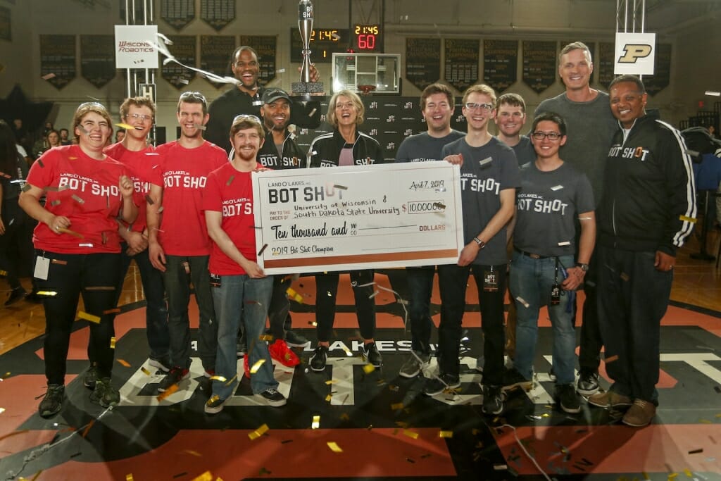 Photo of Robinson holding the trophy with the two winning teams.