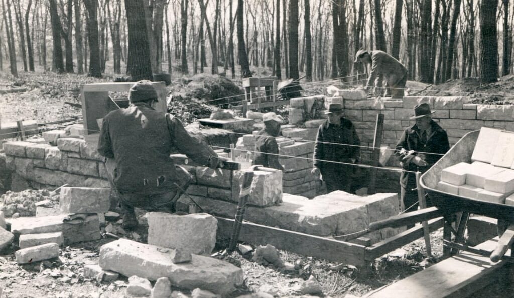 Photo: Workers building a shelter out of large stones
