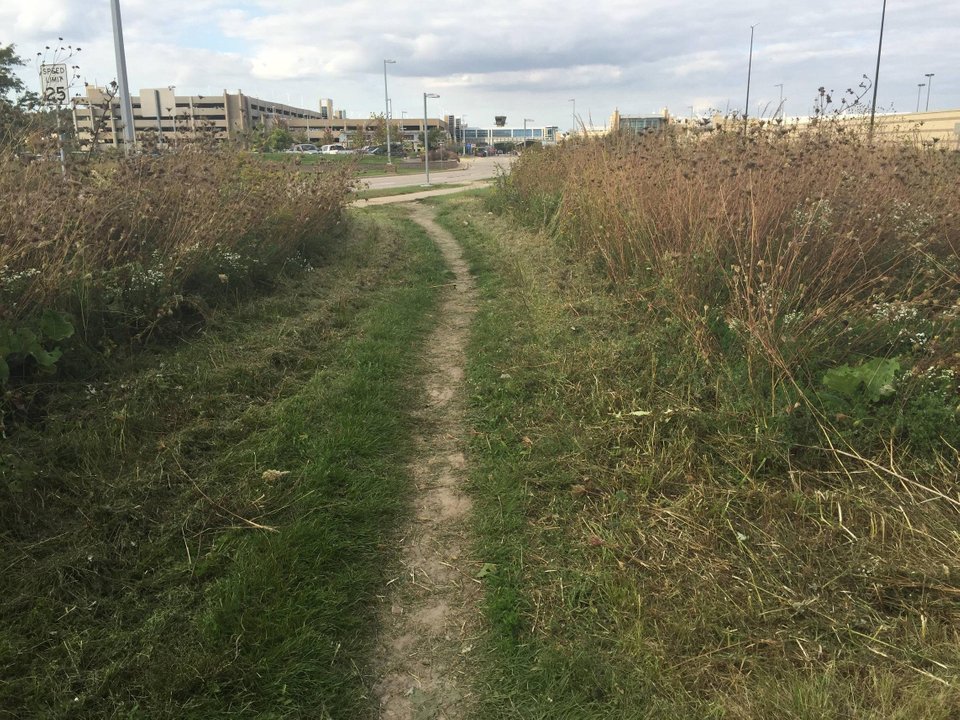 Near Dane County Regional Airport, a desire path cuts through a grassy area. 