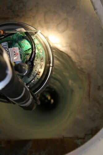Photo: A piece of scientific equipment is lowered into the ice bed.
