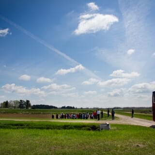 Photo: People gathered in field under sunny skies