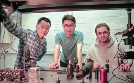 Photo: Three researchers gather in a lab.