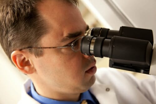Photo: Burkard looking into microscope