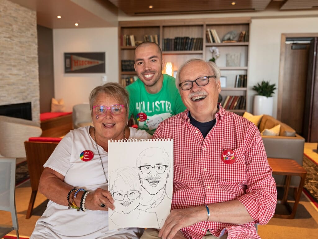 Photo: Three people pose and hold a drawing.