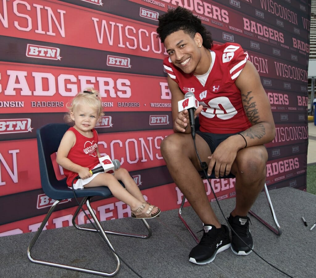 Photo: A player and a young girl hold microphones.
