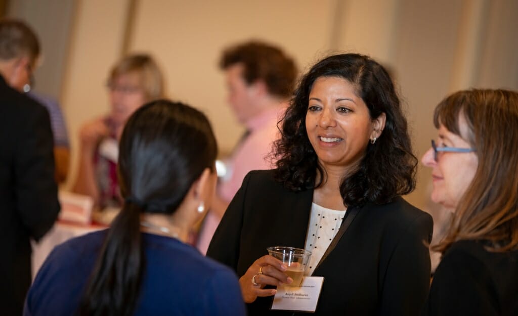 Anjali Sridharan of Facilities Planning and Management talks with others at the reception.