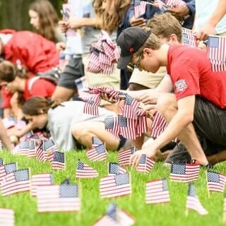 Photo: A student plants a flag in the ground.