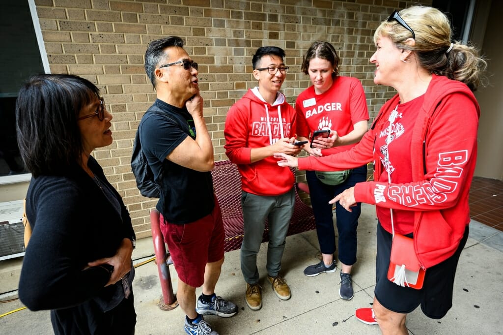 Photo of From left, parents Helen and Calvin Tong and their son Griffin (from San Jose, California) chatting with Dean of Students Christina Olstad and Lori Reesor, vice chancellor for student affairs, as they move into Sellery Residence Hall.