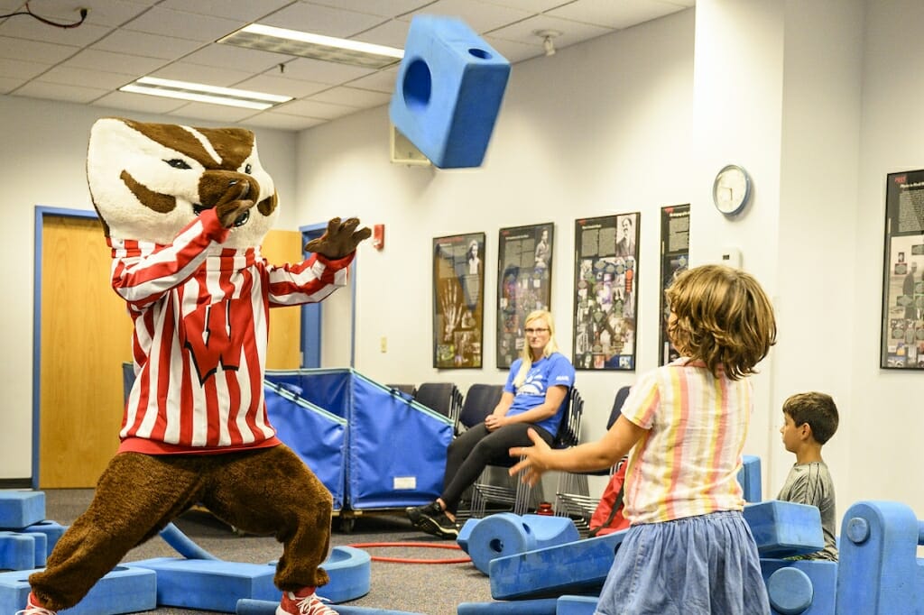 Photo: Bucky Badger plays catch with a young child.