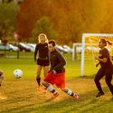 Photo: Soccer players run as the sun sets.
