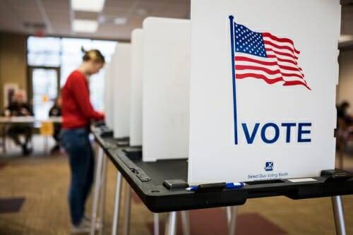 Photo: Closeup of American Flag VOTE sign on a polling booth