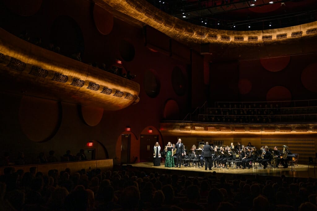 Photo: Singers standing on stage in front of seated musicians