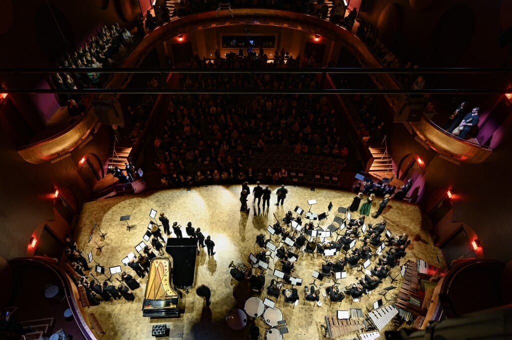 Photo: Overhead view of stage with musicians seated by music stands