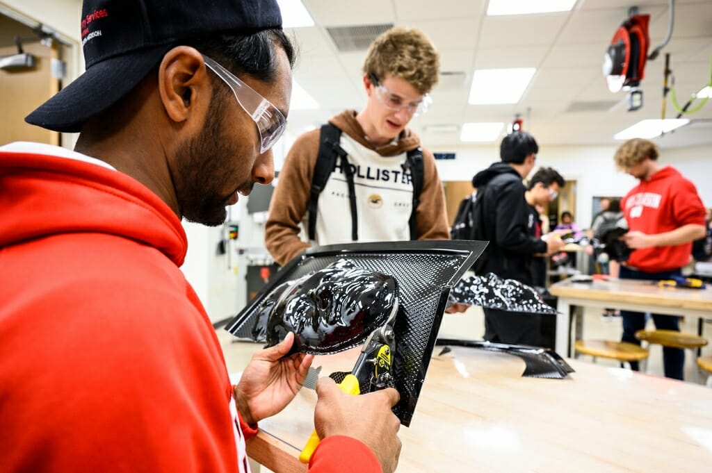 First-year engineering students Alexander Ratnasamy, left, and Ethan Stelzer cut out their formed masks.