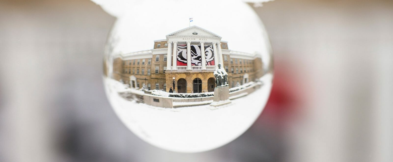 Bascom Hall as seen through a glass sphere in the snow