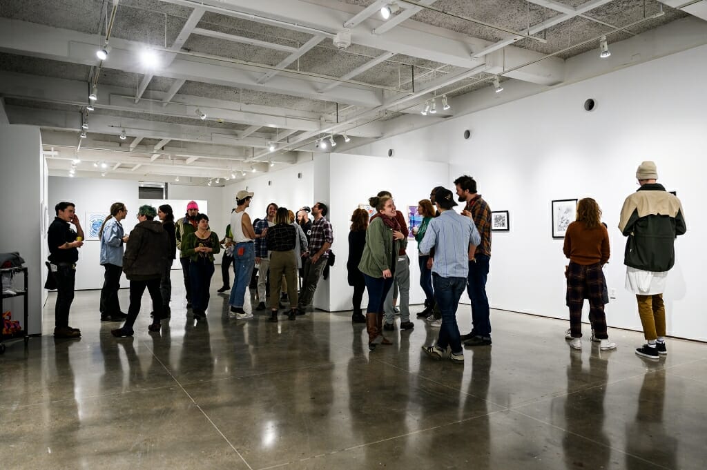 Photo: A crowd of people in an art gallery.