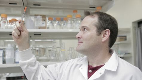 Photo: Kip Ludwig looking at a syringe