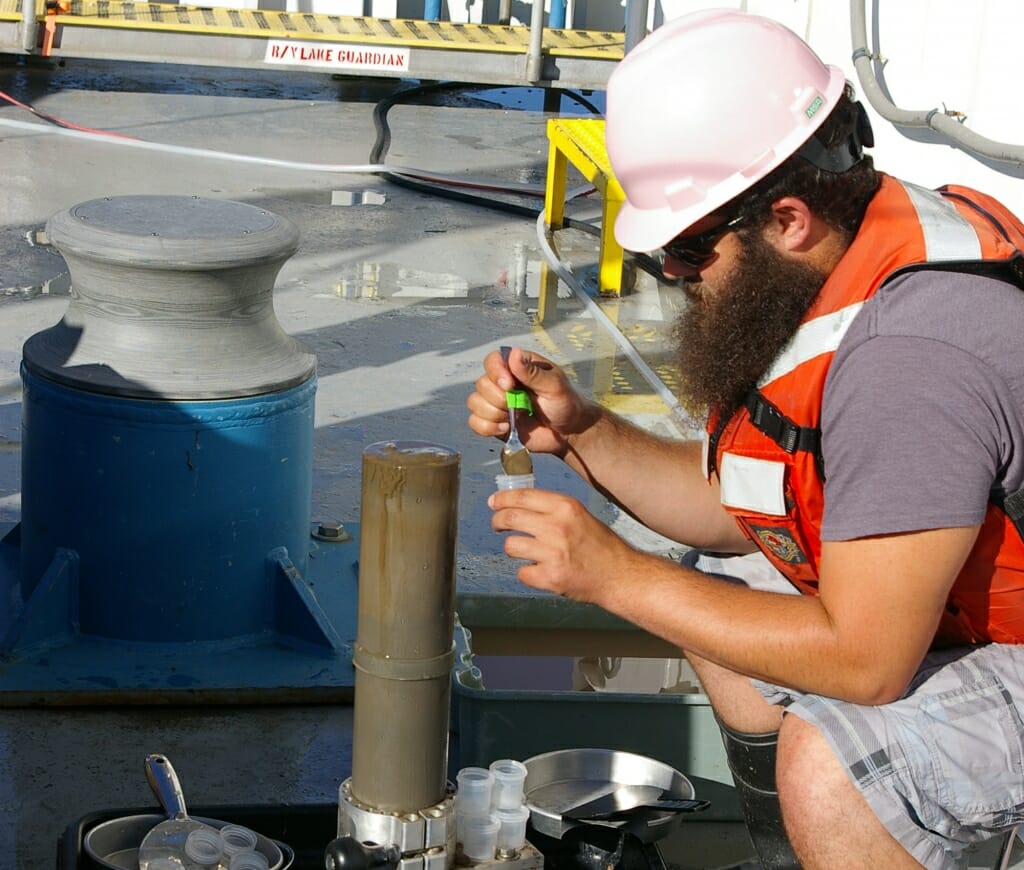 Photo: A man works some equipment on a boat.