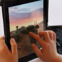 Photo: Hands of child tapping on tablet computer screen
