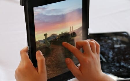 Photo: Hands of child tapping on tablet computer screen