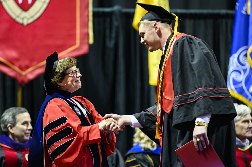 Photo of Chancellor Blank shaking a graduate's hand.
