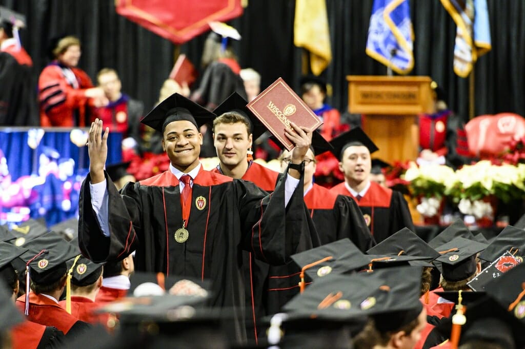 Photo of graduate Brian Mays raising his arms in celebration.
