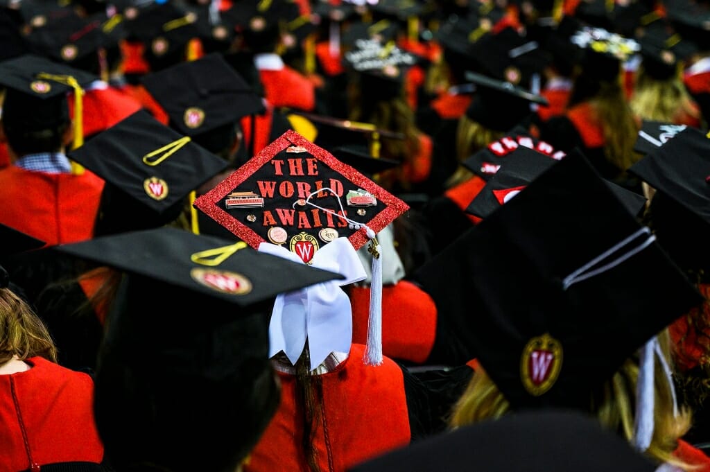 Photo of a mortarboard with stickers of China's Great Wall and Forbidden City and the words "The world awaits."