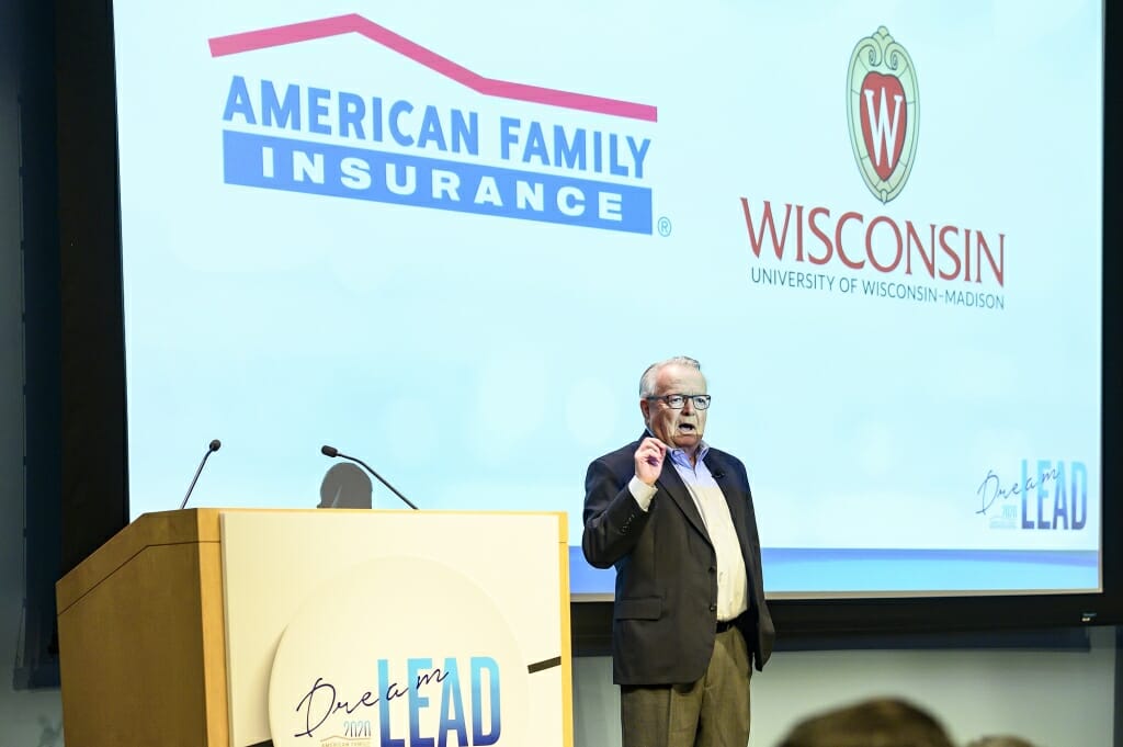 Photo: David Anderson speaking in front of a screen with American Family and UW-Madison logos
