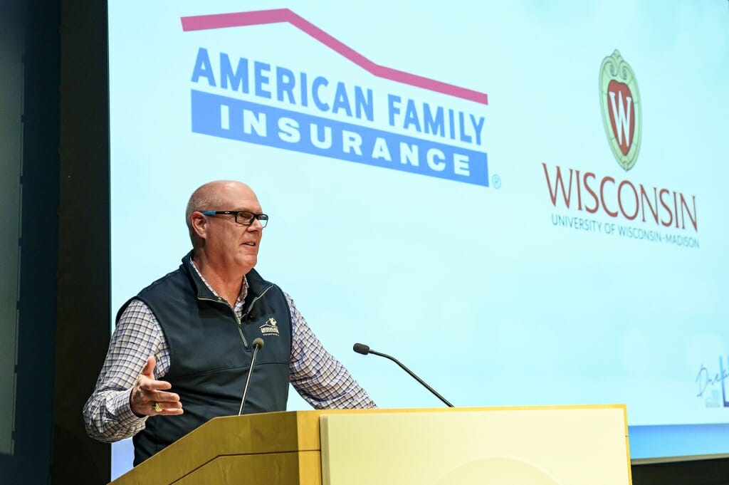Photo: Jack Salzwedel speaking into a microphone at a podium
