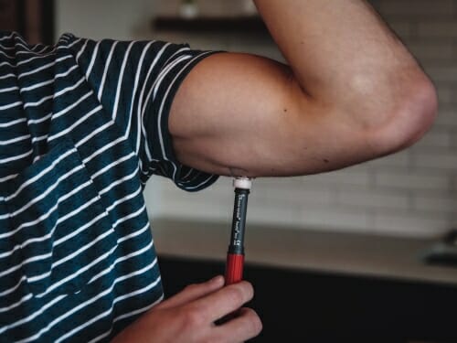 Photo: A needle is injected into the lower part of an upper arm.