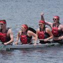 Photo: 4 people in life vests and red headbands rowing a concrete canoe named 