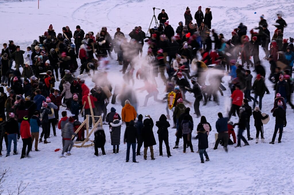 Several dozen people standing in the snow, seen from above