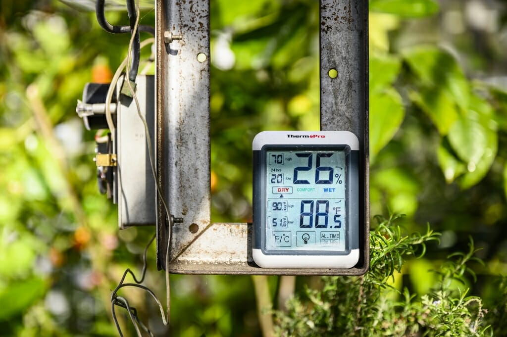 Digital thermometer in a metal bracket reading 26 percent humidity and 88 degrees Fahrenheit