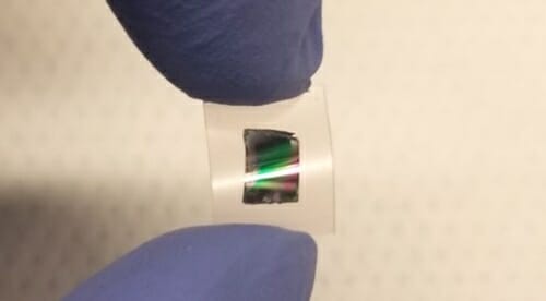 Gloved fingers holding layers of single-crystal oxides
