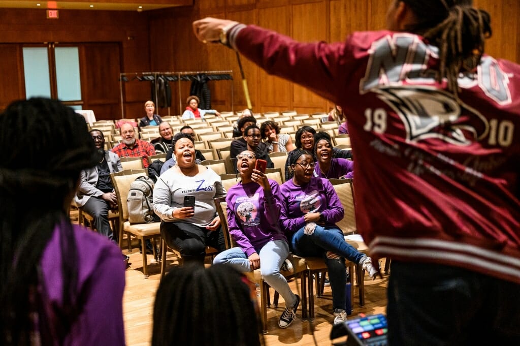 From left to right, audience members Karla Foster, Jaylah Batemon and Karinton DeVille cheer as Freelon leads a freestyle beat-making session during his Black History Month event talk.